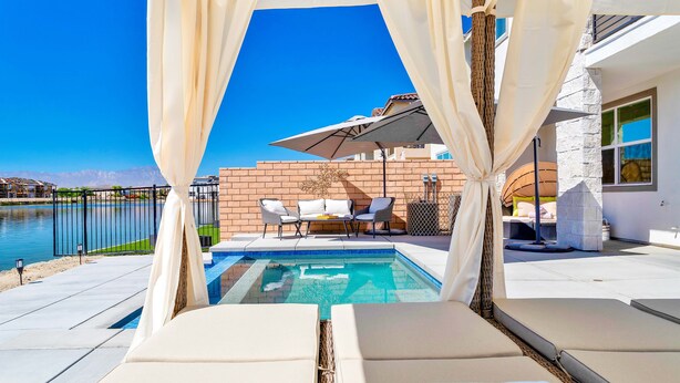An outdoor pool area with lounge chairs and a pergola. - Elegant Villa Brezza Del Lago (Indio)