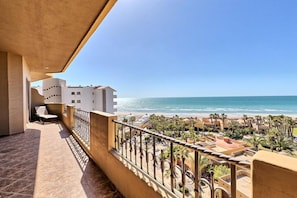 Uma varanda com vista para a praia e o oceano.