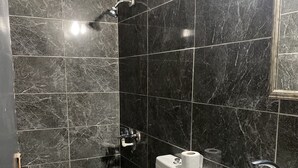 Un baño con inodoro, lavamanos y ducha.