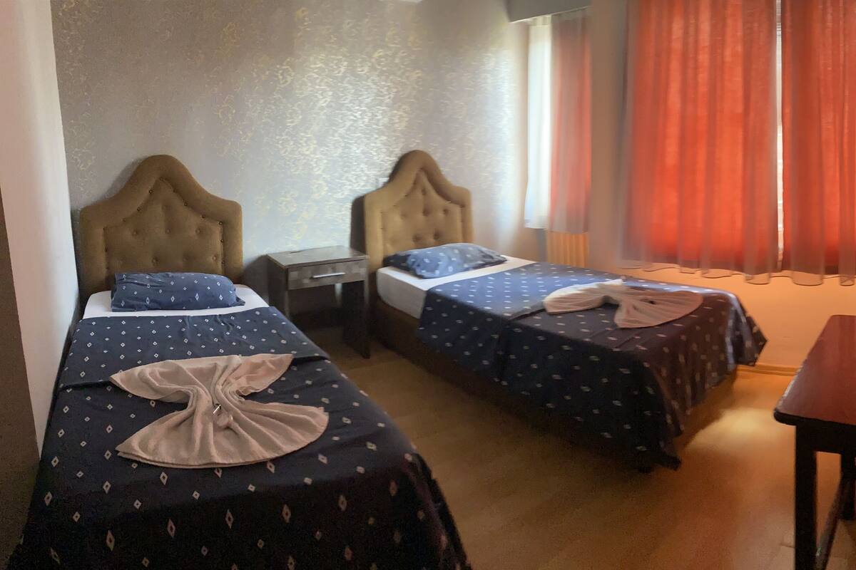 Une chambre d’hôtel avec deux lits, un bureau et une chaise.