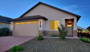 A residential house with a garage, a front door, and a small garden area.