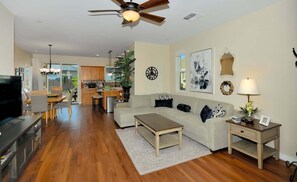 A living room with a sofa, coffee table, TV, and a ceiling fan. - Perfect Location For 5 Surrounding Towns ~ 1 Minute Walk To Golf (Cottonwood)