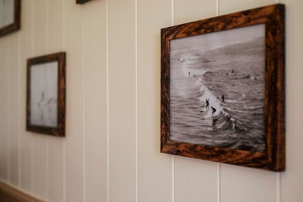 A hallway with framed photographs on the wall. - NEW - Paddler`s Inn 3BR Hilo (Hilo)