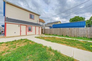 A two-story house with a red door and beige siding. - Spacious and Fun 5BR w/ Pool Table and more! (Indianapolis)
