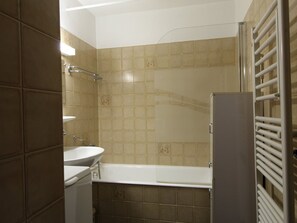 A bathroom with a bathtub, a sink, and a toilet. - Cozy Studio for 4: Terrace, Dishwasher, Washer, Ski-In/Ski-Out Access (Les Carroz d'Arâches)