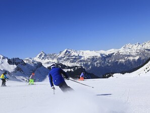 Skiers on a snowy slope with snow-covered mountains in the background. - Cozy Studio for 4: Terrace, Dishwasher, Washer, Ski-In/Ski-Out Access (Les Carroz d'Arâches)