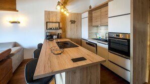 Eine moderne Küche mit Holzausstattung, einer zentralen Kochinsel und einem eingebauten Ofen.