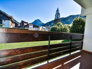 Un balcone con ringhiera in legno affacciato su un paesaggio montuoso.
