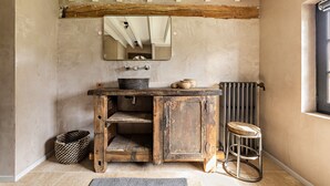 A rustic bathroom with a wooden vanity, a mirror, a radiator, and a window. - Magnificent house in Normandy (ROSAY SUR LIEURE)