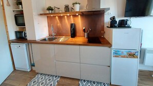 A compact kitchen with a sink, countertop, and a refrigerator. - Cozy 2-room apartment in La Plagne, near the slopes (La Plagne-Tarentaise)