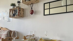A dining table set with white bowls, wine glasses, and cutlery, with a yellow placemat. - Cozy 2-room apartment in La Plagne, near the slopes (La Plagne-Tarentaise)