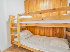 A bunk bed with a wooden headboard and a lower bed with a mattress and pillows. - Studio in Morzine center, 4 pers, balcony, WIFI (Morzine)
