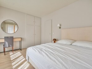 A bedroom with a bed, a desk, a chair, a wardrobe, and a mirror. - Central T4 Apartment with Parking, Near Ski Lifts – Sleeps 6 (Morzine)