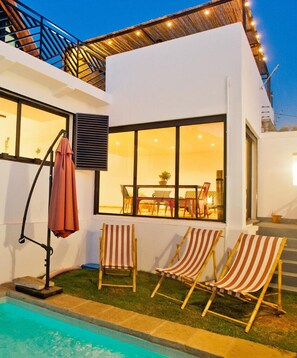 A modern house with a pool, outdoor seating, and a dining area visible through large windows. - Joyau secret # Jardin # Piscine # prox centre ville (Antananarivo)