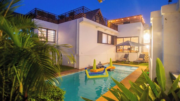 Ein modernes Haus mit Swimmingpool, umgeben von viel Grün.