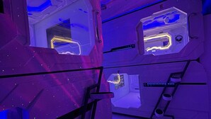 Une pièce futuriste avec un plafond étoilé, un croissant de lune et un panneau de contrôle doté de boutons lumineux.