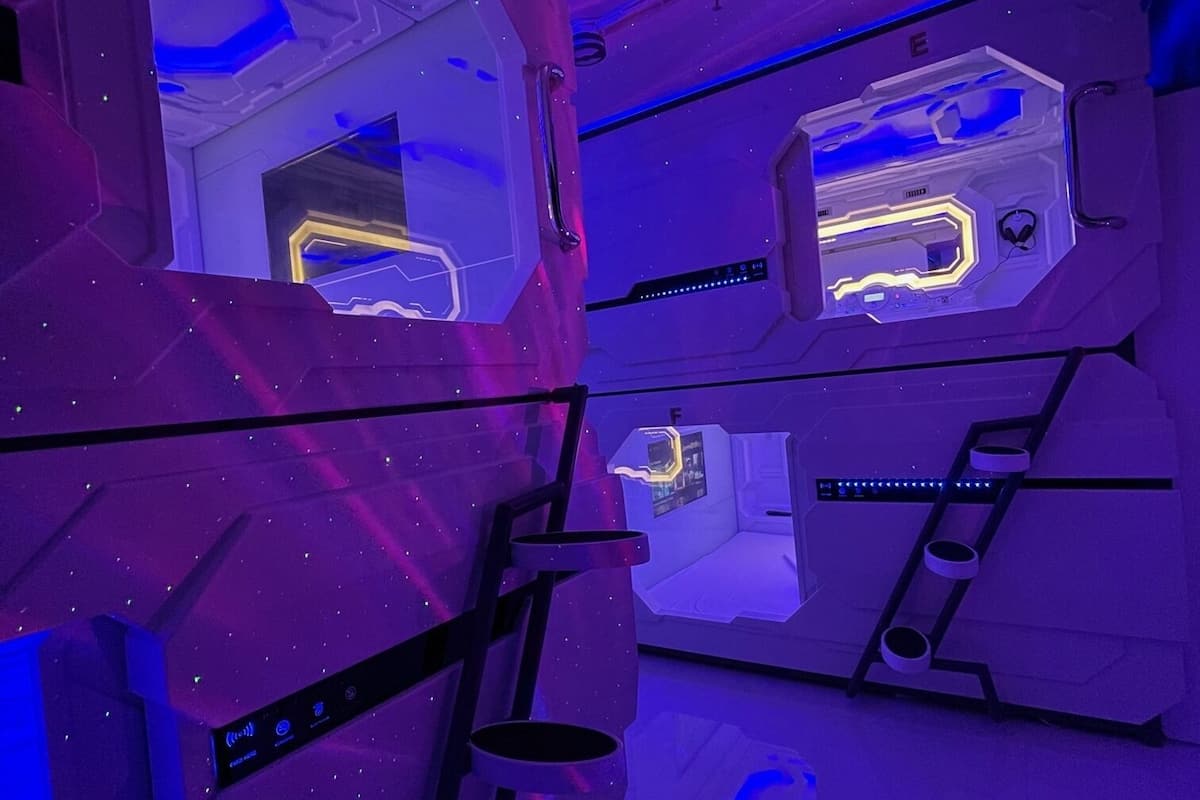 A futuristic room with a starry ceiling, a crescent moon, and a control panel with illuminated buttons.