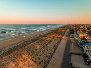 Stroll along the beachfront promenade, surrounded by charming houses with balconies and decks.