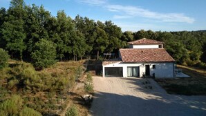 A modern house with a tiled roof, surrounded by dense trees and a gravel driveway. - Modern villa, ideal for families, at the gateway to the VERDON! (83111 - AMPUS)