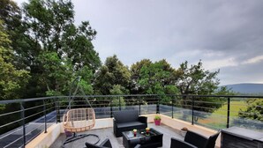 A rooftop terrace with outdoor furniture, potted plants, and a view of the surrounding landscape. - Modern villa, ideal for families, at the gateway to the VERDON! (83111 - AMPUS)