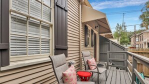 Una terraza de madera con mobiliario exterior y una zona cubierta.