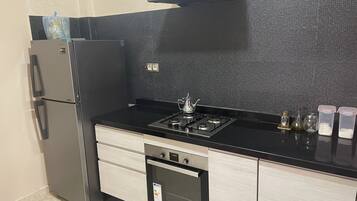 Een koelkast, een oven, eettafels