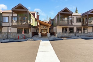 A multi-story building with a central entrance, balconies, and a stone facade. - Comfy, Ski-In Condo with Free WiFi & Shared Hot Tub and Sauna - Walk to town (Breckenridge)