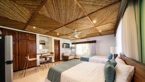 A hotel room with a wooden ceiling, a bed with green and white bedding, a desk with a chair, a TV, and a window with curtains. - Villa Potrero Luxury Private Beachfront Home with Housekeeper, Concierge (Provincia de Guanacaste)