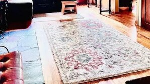 A cozy living room with a sofa, a rug, and a wooden floor. - Cozy Private home (Warrensburg)
