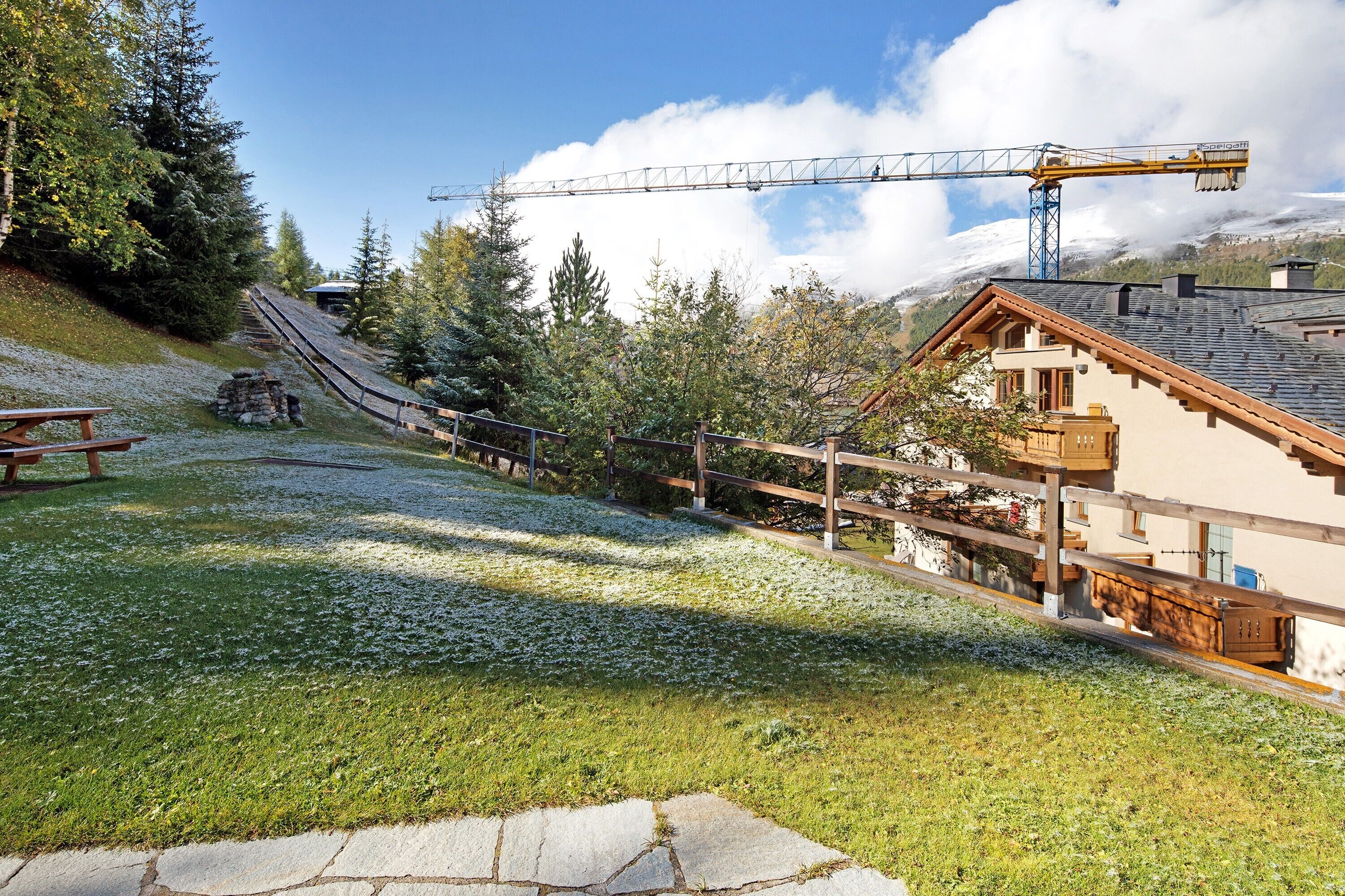 A ski lift, wooden buildings, and a stone pathway.