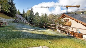 Un telesilla, edificios de madera y un sendero de piedra.