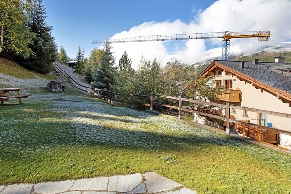 Un télésiège, des bâtiments en bois et un sentier pavé de pierres.