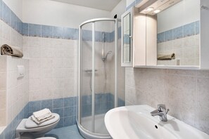 Une salle de bain équipée d’une douche, de toilettes et d’un lavabo.