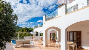 A modern villa with a swimming pool, outdoor seating, and a view of the hills. - Villa 'Font de Sa Cala' with Sea View, Wi-Fi and Air Conditioning (Provensals)