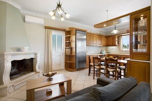 Une cuisine moderne avec des meubles en bois, un réfrigérateur encastré et un coin repas comprenant des chaises et une table.