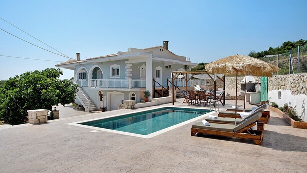 A swimming pool with lounge chairs, a covered seating area, and a staircase leading to a balcony. - Apartment 'Christine's House' with Private Pool, Wi-Fi and Air Conditioning (Zakynthos)