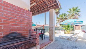 A brick barbecue grill, outdoor seating with chairs, a table, and a blue umbrella. - Pet-Friendly Holiday Home 'Casa Nico' close to the Sea with Terrace (Augusta)