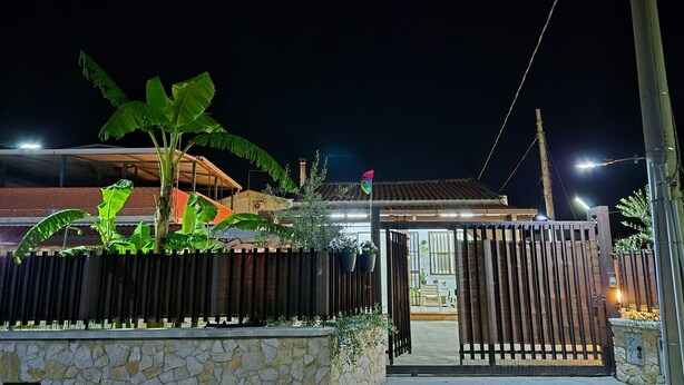 A gated property with a stone wall, a wooden fence, and a house with a tiled roof. - Pet-Friendly Holiday Home 'Casa Nico' close to the Sea with Terrace (Augusta)