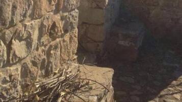 Um edifício de pedra com telhado inclinado e uma entrada pequena.