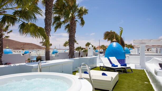 A rooftop pool area with a hot tub, lounge chairs, and blue domes. - Vacation Home "Villa 82" with Mountain View, Pool & Wi-Fi (Corralejo)