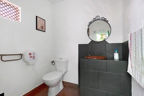A bathroom with a toilet, a sink, a mirror, a hand dryer, and a towel rack. - Vacation Home 'Casa Haba' with Sea View, Terrace & Wi-Fi (Sauzal)