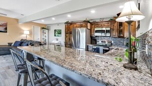 A modern kitchen with granite countertops, stainless steel appliances, and wooden cabinets. - Painted Paradise Guest Suite | Romantic Hill Country Sunsets with a swimming poo (New Braunfels)