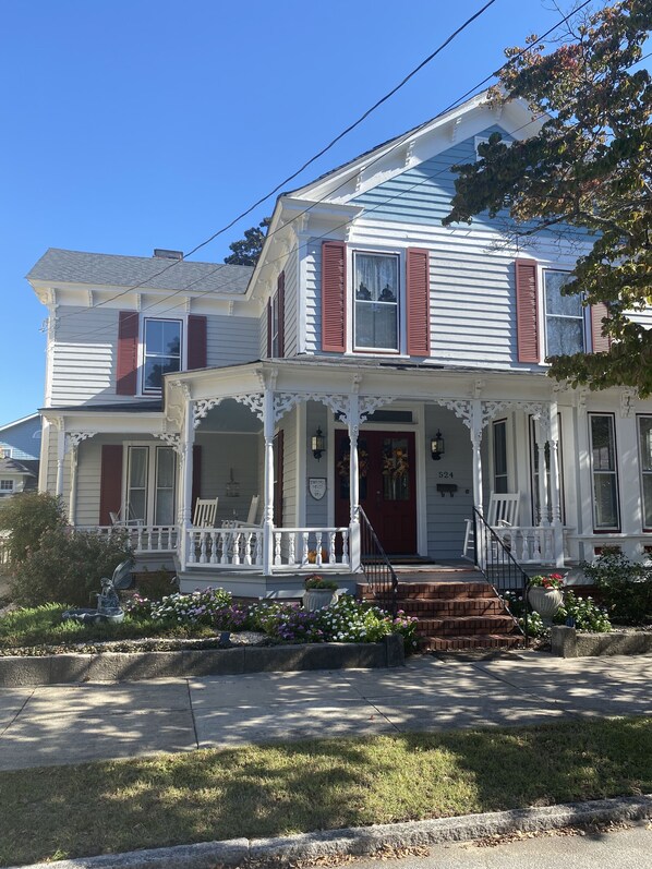 A two-story house with a porch, a front door, and a number '524' on the side.