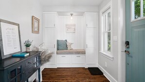 A hallway with a bench, a framed menu, and a door.