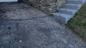Une maison à deux étages avec un escalier en pierre menant à un porche.