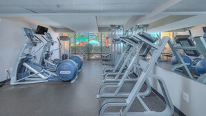 Ein Fitnessstudio mit Laufbändern, Crosstrainern und Krafttrainingsgeräten.