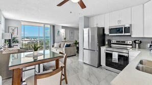 Una cocina moderna con comedor, ventanas amplias y ventilador de techo.