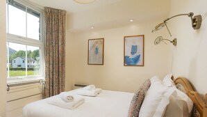 A hotel room with a bed, two paintings, a window with curtains, and a bedside lamp. - Oak Cottage, Chapel Stile (Chapel Stile)