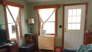 Una sala de estar acogedora con un mueble de madera, un sofá azul y un aparador de madera.