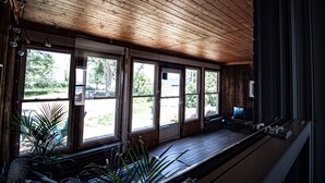 A room with wooden ceiling and large windows.